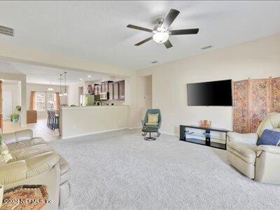 carpeted living room with ceiling fan