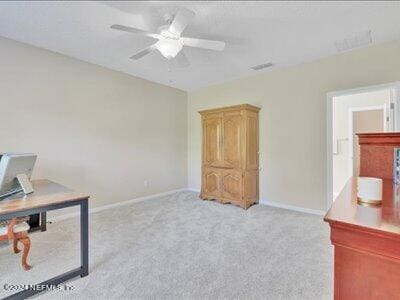 home office featuring light carpet, visible vents, baseboards, and ceiling fan