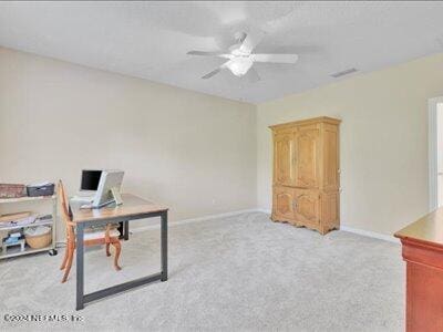 carpeted office space with ceiling fan