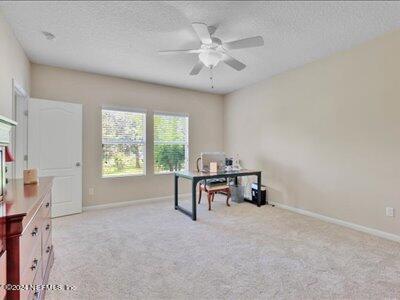 home office with ceiling fan, a textured ceiling, and light carpet