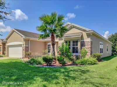 ranch-style house with a garage and a front yard