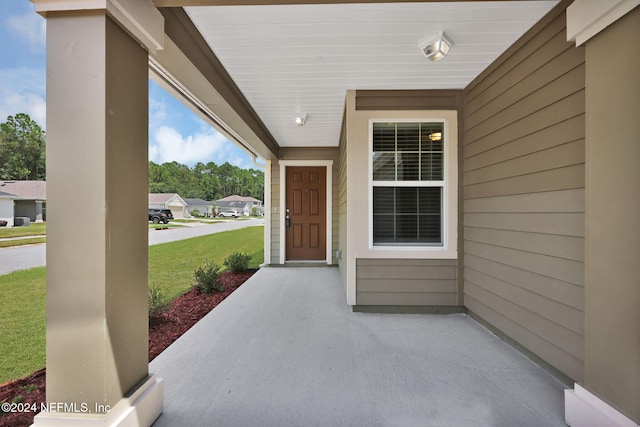 view of exterior entry featuring a yard