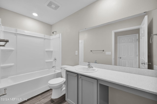 full bathroom with bathtub / shower combination, wood-type flooring, toilet, and vanity