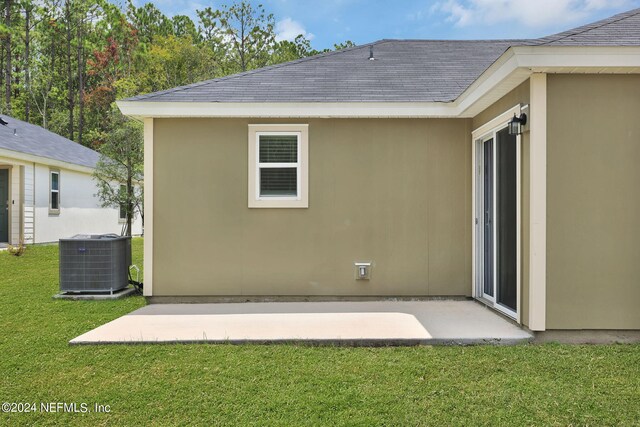 rear view of property featuring central AC, a yard, and a patio area