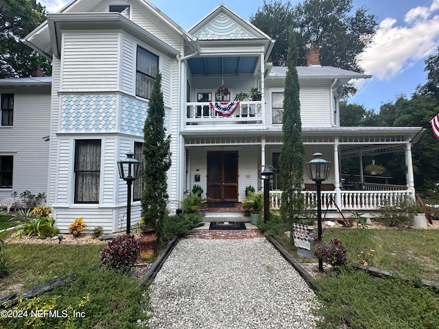 view of front of property featuring covered porch and a balcony