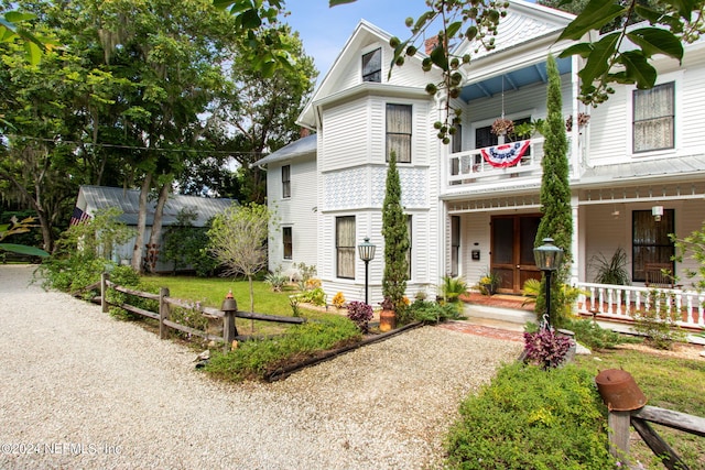 view of front facade featuring covered porch and a balcony