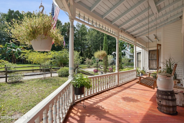 deck featuring covered porch and a lawn