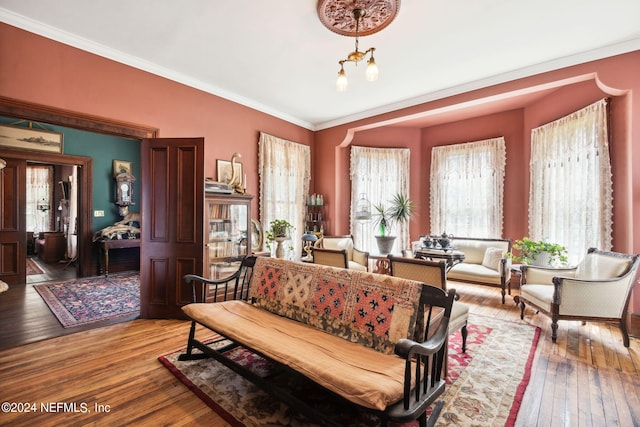 interior space with ornamental molding, hardwood / wood-style floors, and a notable chandelier