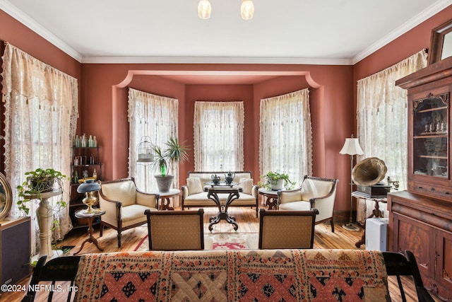 sitting room with light wood-type flooring and crown molding