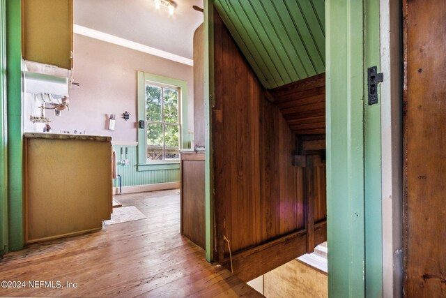 corridor featuring water heater, crown molding, and hardwood / wood-style floors