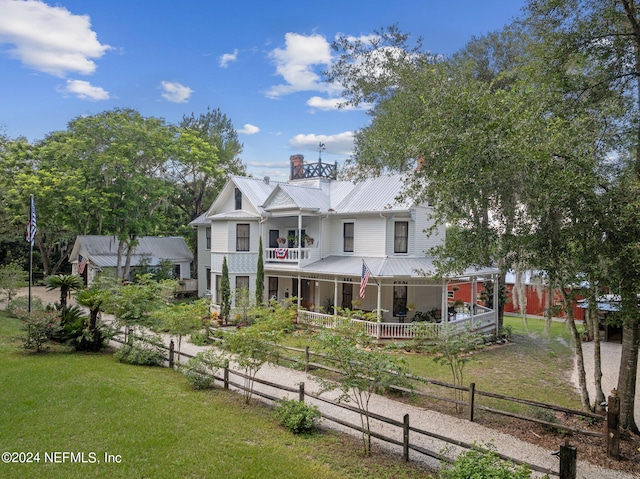 view of front of home featuring a balcony, a front lawn, and a porch