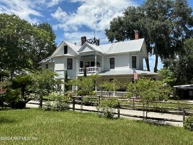 view of front facade featuring a front lawn and a balcony