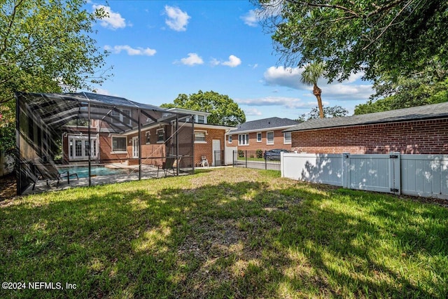 view of yard with glass enclosure, a patio, and a fenced in pool