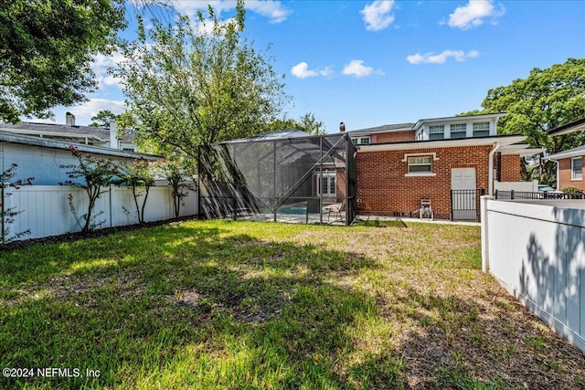 view of yard with a swimming pool and glass enclosure