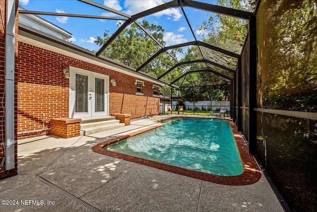 view of swimming pool with a patio area, french doors, and a lanai