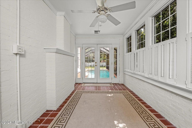 unfurnished sunroom featuring ceiling fan and french doors