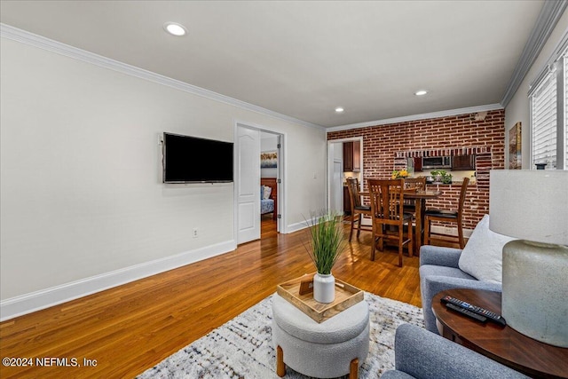 living room with hardwood / wood-style flooring, crown molding, and brick wall