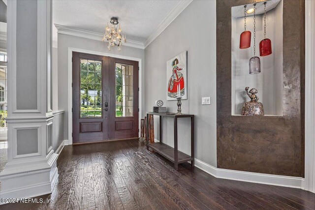 entryway featuring french doors, ornamental molding, a textured ceiling, dark hardwood / wood-style flooring, and a chandelier