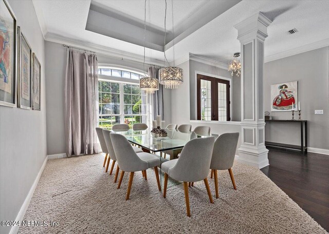 dining area with decorative columns, ornamental molding, dark hardwood / wood-style floors, and a notable chandelier