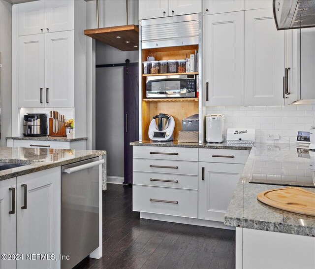 kitchen featuring a barn door, white cabinetry, dark hardwood / wood-style floors, and appliances with stainless steel finishes