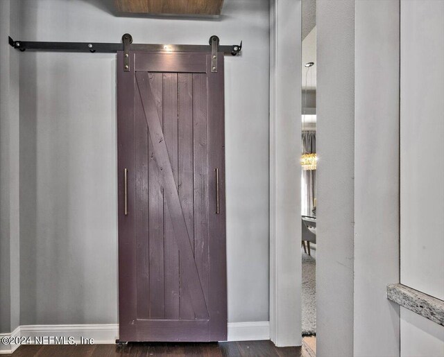 details with a barn door and hardwood / wood-style floors