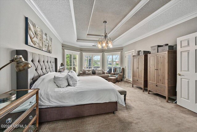 bedroom with carpet, ornamental molding, a textured ceiling, and a chandelier