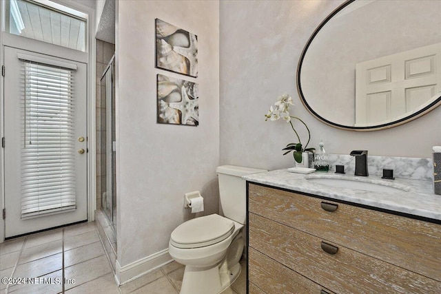 bathroom with tile patterned floors, vanity, toilet, and a shower with door