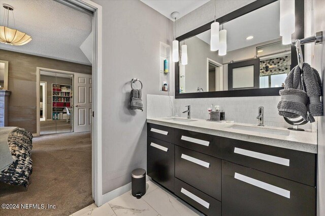 bathroom with vanity, a textured ceiling, and tasteful backsplash