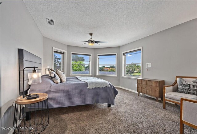 bedroom featuring ceiling fan, carpet floors, and a textured ceiling