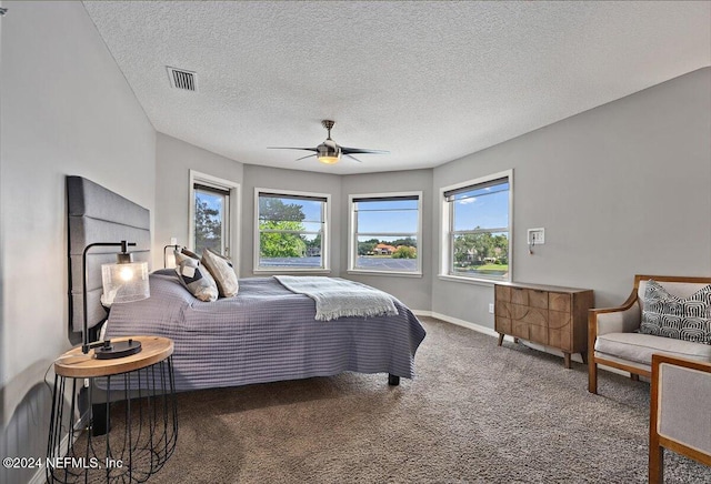 bedroom with baseboards, visible vents, a ceiling fan, a textured ceiling, and carpet flooring