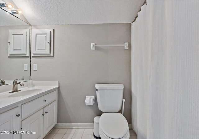 bathroom featuring tile patterned floors, vanity, toilet, and a textured ceiling