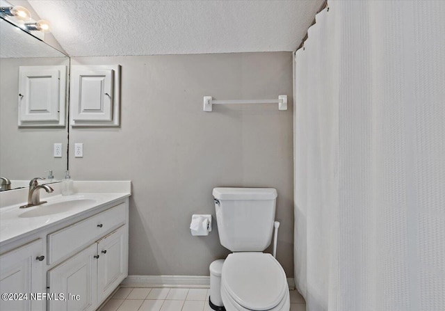 bathroom featuring toilet, vanity, a textured ceiling, baseboards, and tile patterned floors