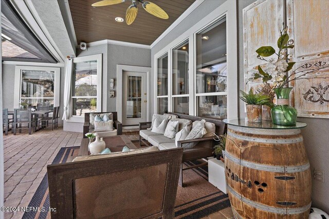 sunroom featuring ceiling fan and wooden ceiling