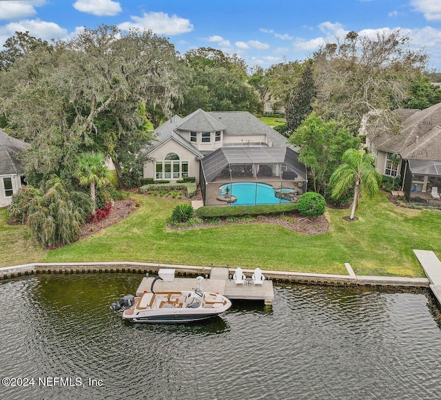 rear view of property with a yard, an outdoor pool, glass enclosure, and a water view