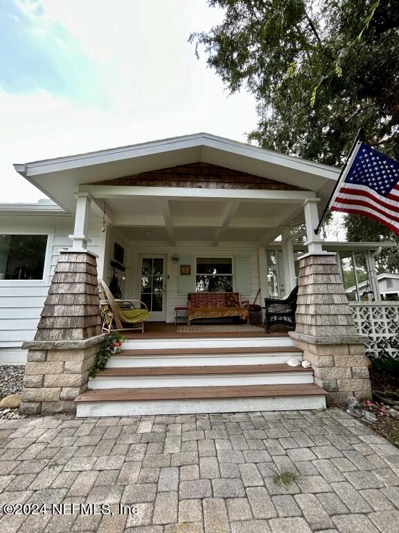 view of exterior entry with a porch