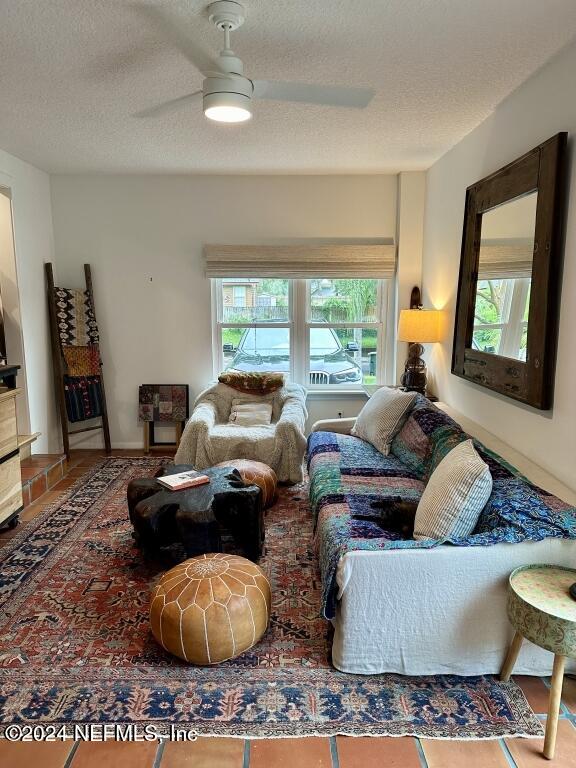 tiled bedroom featuring multiple windows, a textured ceiling, and ceiling fan