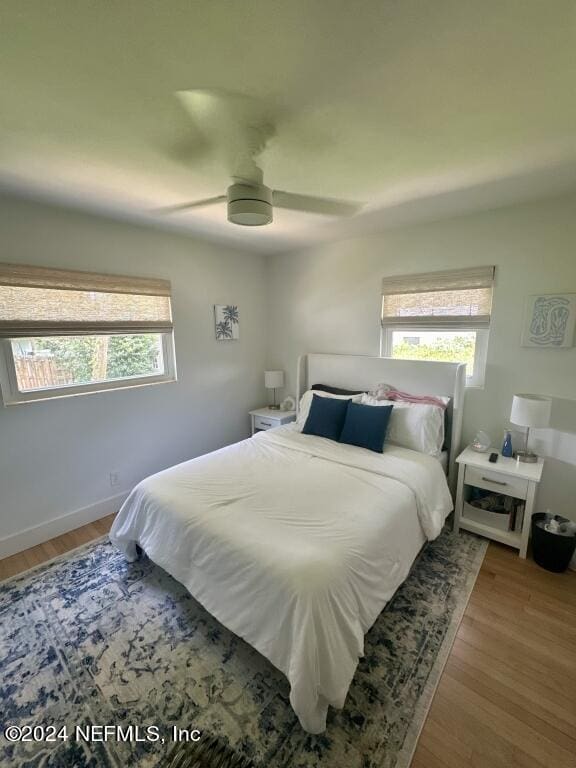 bedroom featuring hardwood / wood-style flooring, multiple windows, and ceiling fan