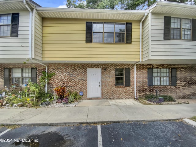 townhome / multi-family property featuring uncovered parking and brick siding