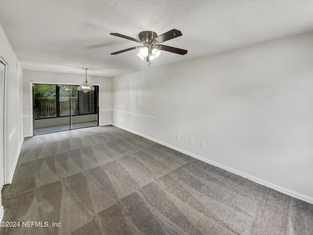 carpeted empty room featuring ceiling fan and a textured ceiling