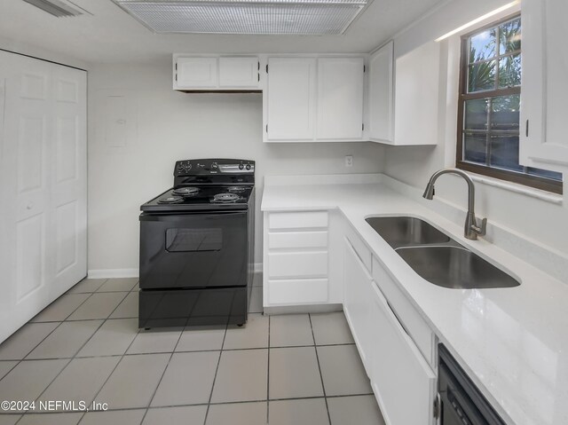 kitchen with sink, black range with electric stovetop, white cabinets, and light tile patterned floors