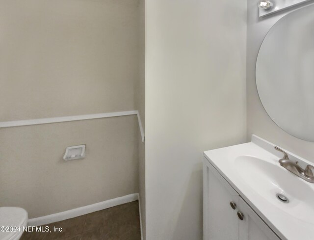 bathroom with tile patterned flooring, toilet, and vanity