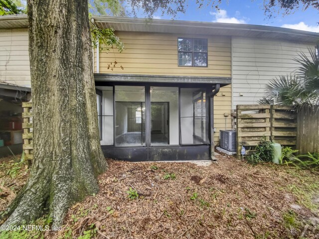 rear view of property featuring central air condition unit and a sunroom