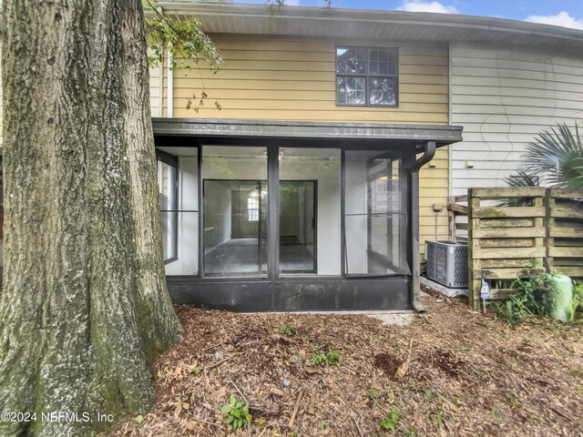 back of property with a sunroom and cooling unit