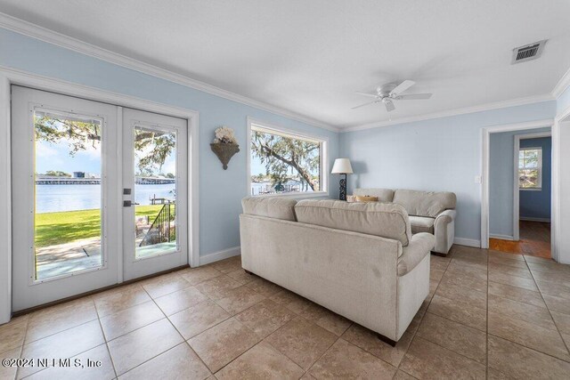 living room with tile patterned floors, french doors, a water view, ceiling fan, and ornamental molding