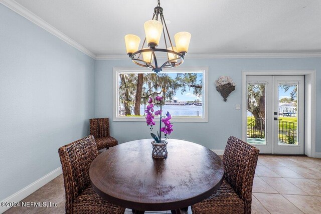 tiled dining space featuring plenty of natural light, a chandelier, crown molding, and french doors