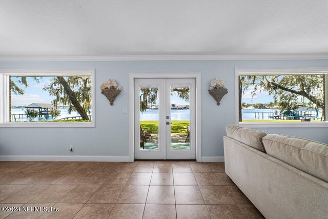 entryway featuring ornamental molding, french doors, a water view, and tile patterned floors