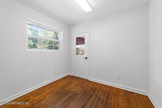 empty room with baseboards and dark wood finished floors