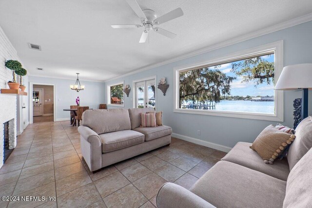 tiled living room with ceiling fan with notable chandelier, crown molding, and a water view