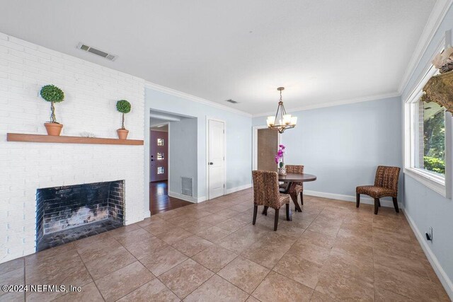 dining room featuring ornamental molding, a notable chandelier, and a brick fireplace