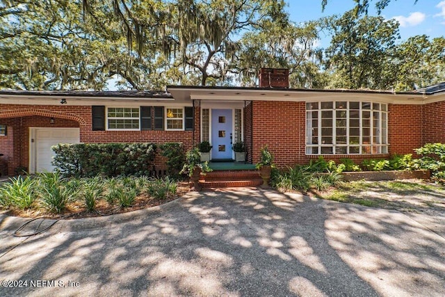 single story home with brick siding and a chimney